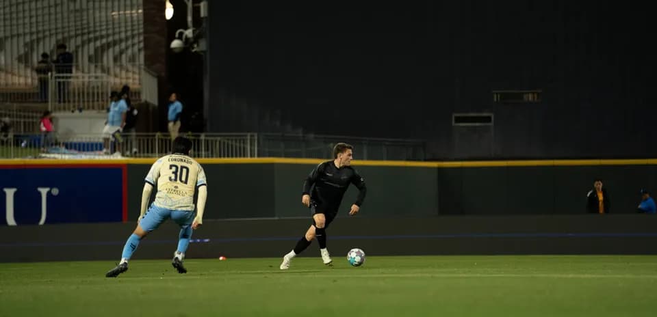 Jugador corriendo con el balón en el partido