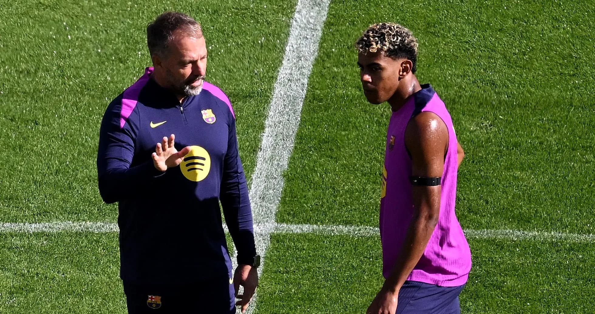 Entrenador hablando con jugador en campo de entrenamiento