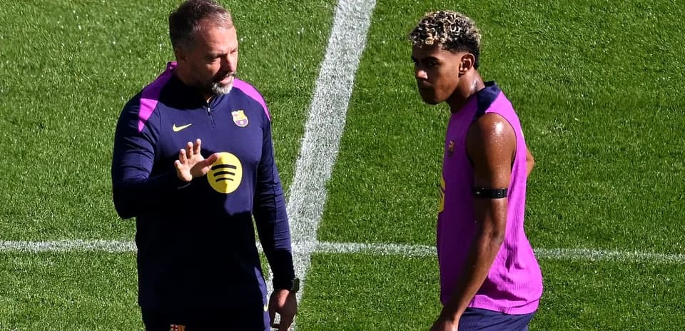 Entrenador hablando con jugador en campo de entrenamiento