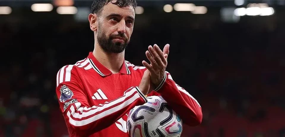 Jugador aplaudiendo con balón en el estadio