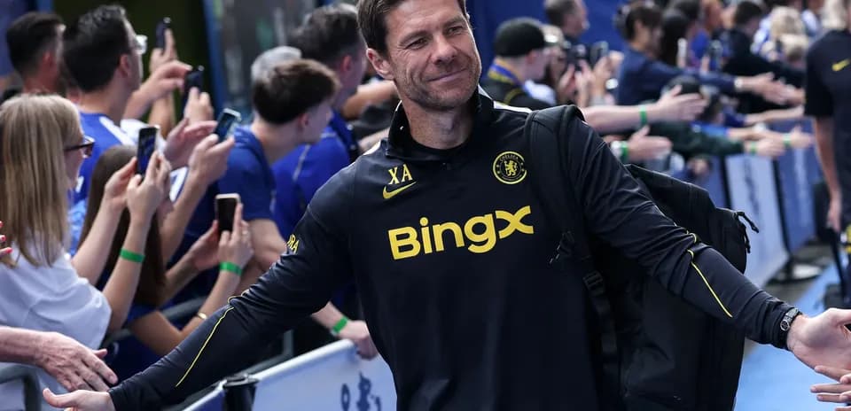 Entrenador saludando a aficionados en evento deportivo