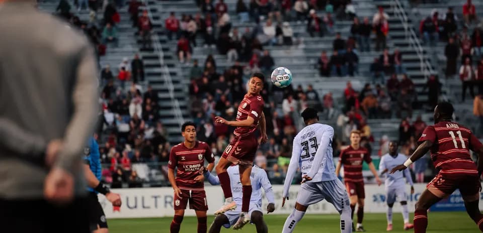 Jugadores compitiendo por el balón en el partido