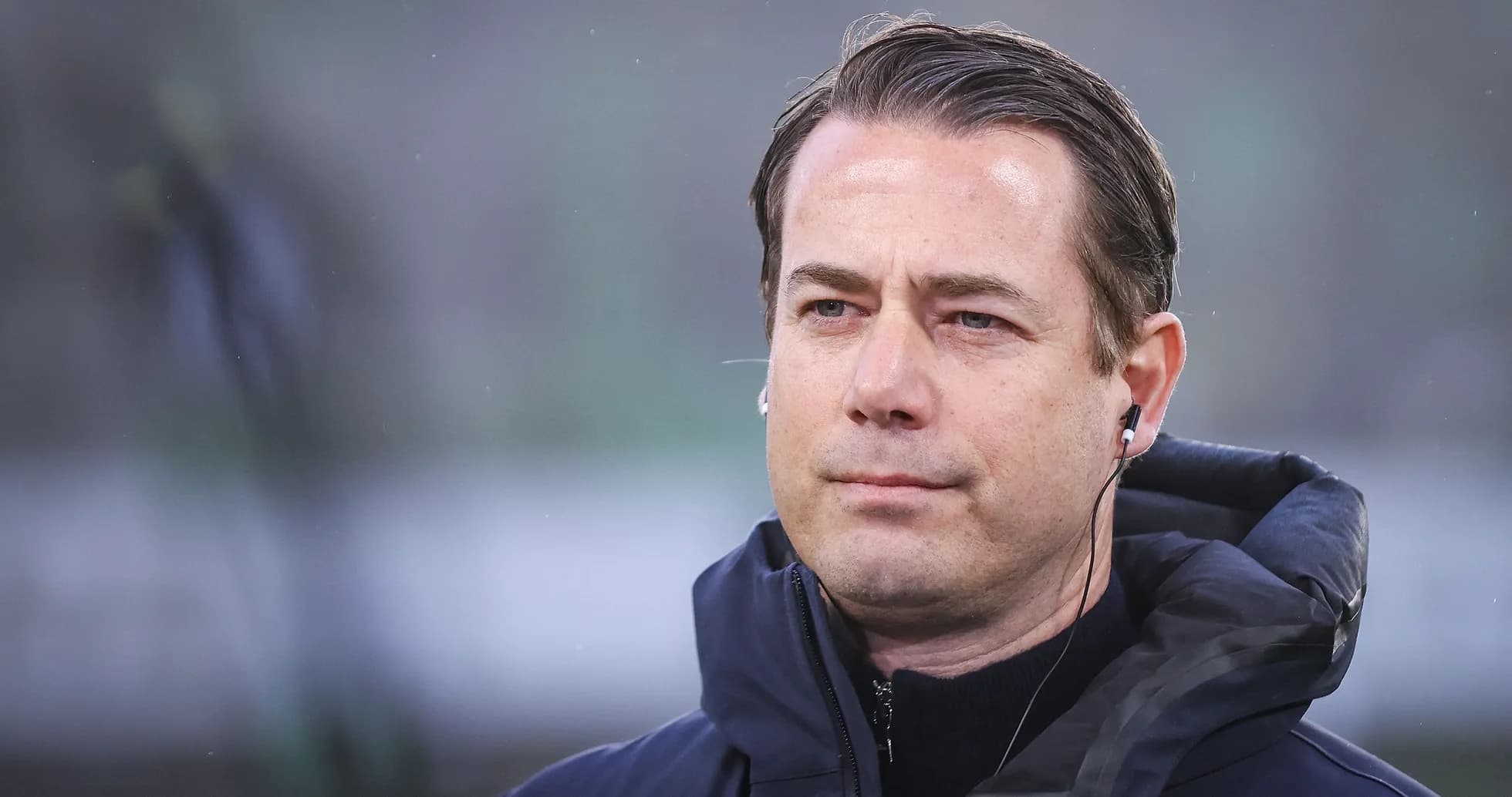 Entrenador con auriculares en el banquillo