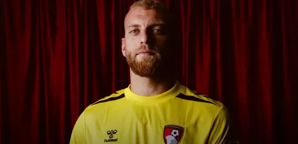 Portero de AFC Bournemouth posando con uniforme amarillo