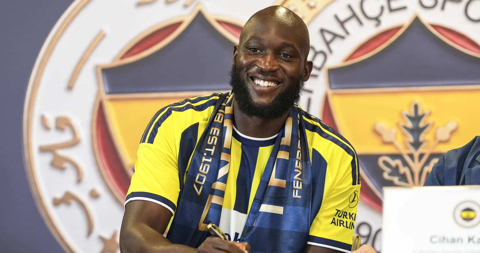 Jugador firmando contrato con Fenerbahçe en conferencia