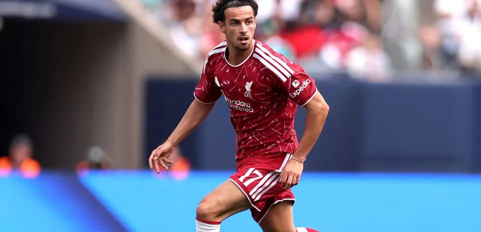 Jugador de Liverpool corriendo con balón en el campo