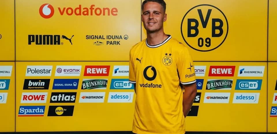 Jugador posando con camiseta amarilla de Borussia Dortmund