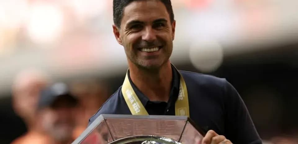 Entrenador sosteniendo trofeo en ceremonia de premiación