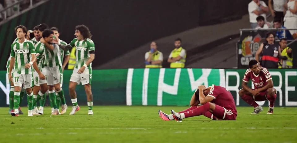 Jugadores de Betis celebrando mientras oponente se lamenta