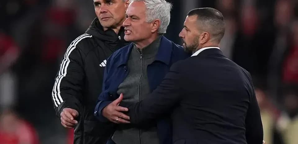 Entrenador siendo contenido por asistentes tras partido