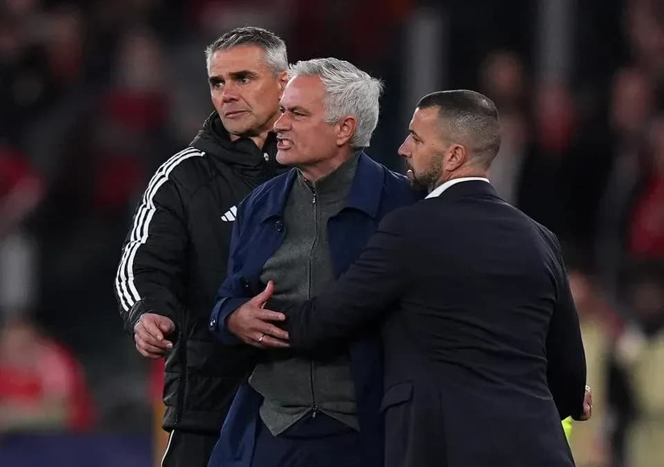 Entrenador siendo contenido por asistentes tras partido