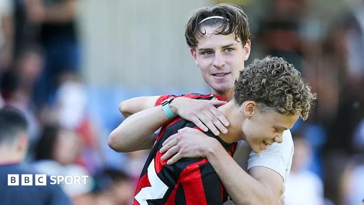 Dos jugadores abrazándose en el campo de fútbol