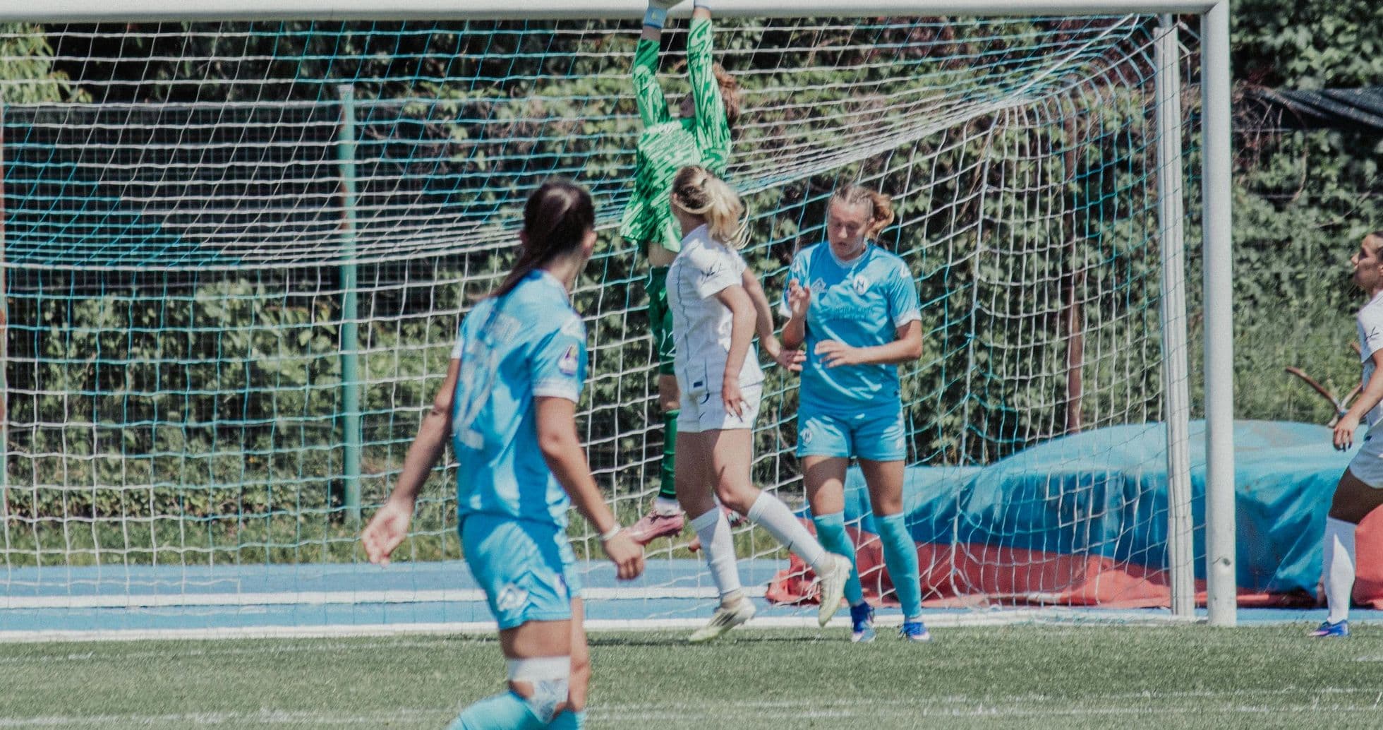 Portera atrapando el balón en partido de fútbol