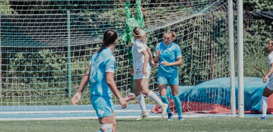 Portera atrapando el balón en partido de fútbol