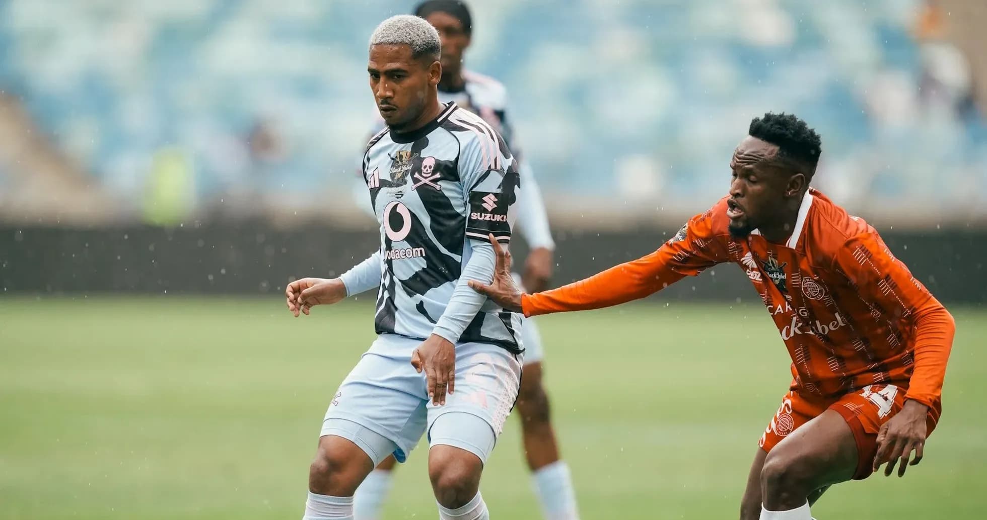 Jugador en acción durante partido de fútbol bajo lluvia