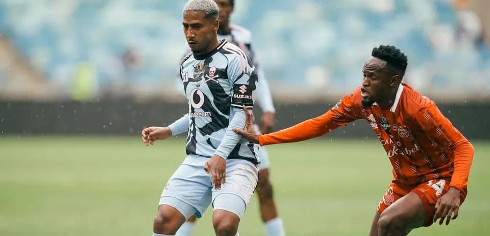 Jugador en acción durante partido de fútbol bajo lluvia
