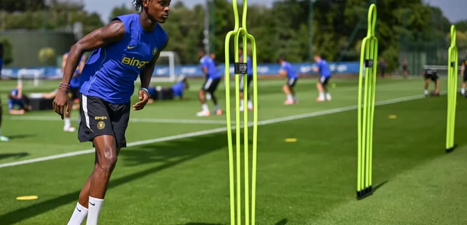 Jugador entrenando en campo con conos de entrenamiento