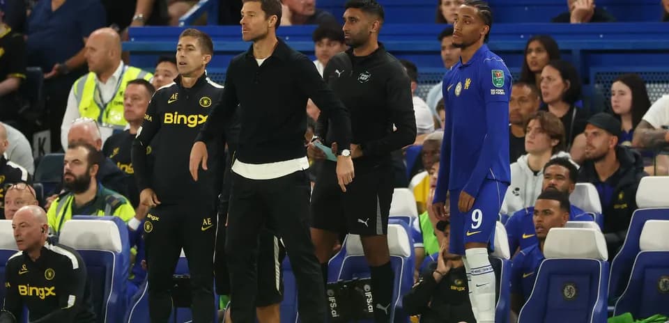 Entrenadores y jugador en la banca durante partido