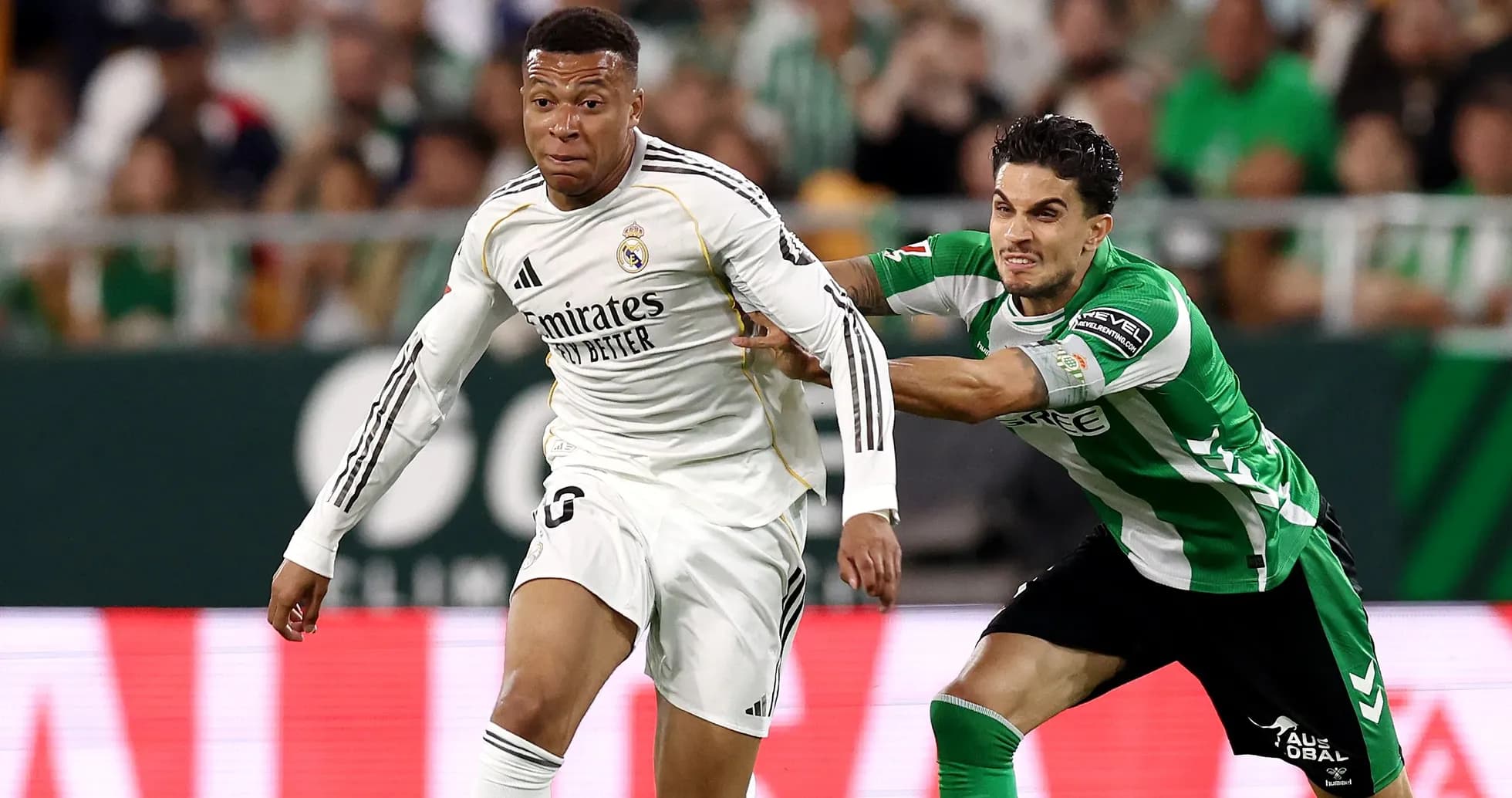 Jugador de Real Madrid superando a defensor de Betis