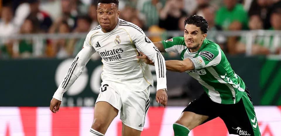 Jugador de Real Madrid superando a defensor de Betis
