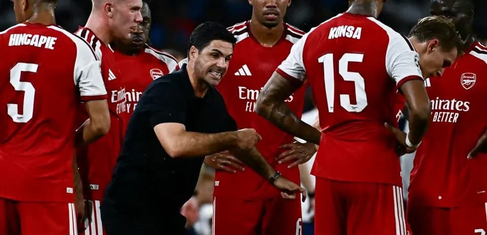 Entrenador dando instrucciones a jugadores de Arsenal