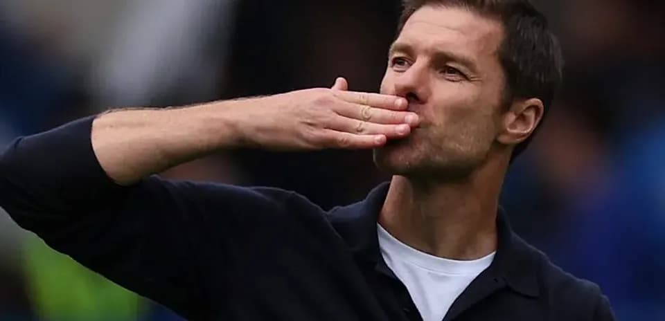 Entrenador saludando a los aficionados con un beso