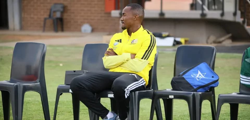 Entrenador sentado en la banca durante el entrenamiento