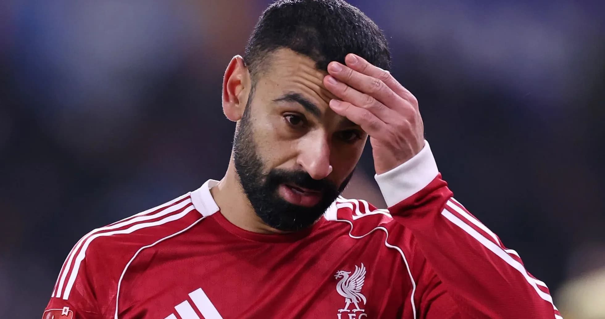 Jugador de Liverpool con camiseta roja tocándose la cabeza