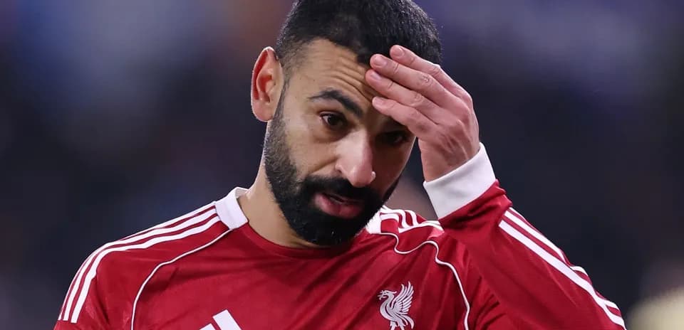 Jugador de Liverpool con camiseta roja tocándose la cabeza