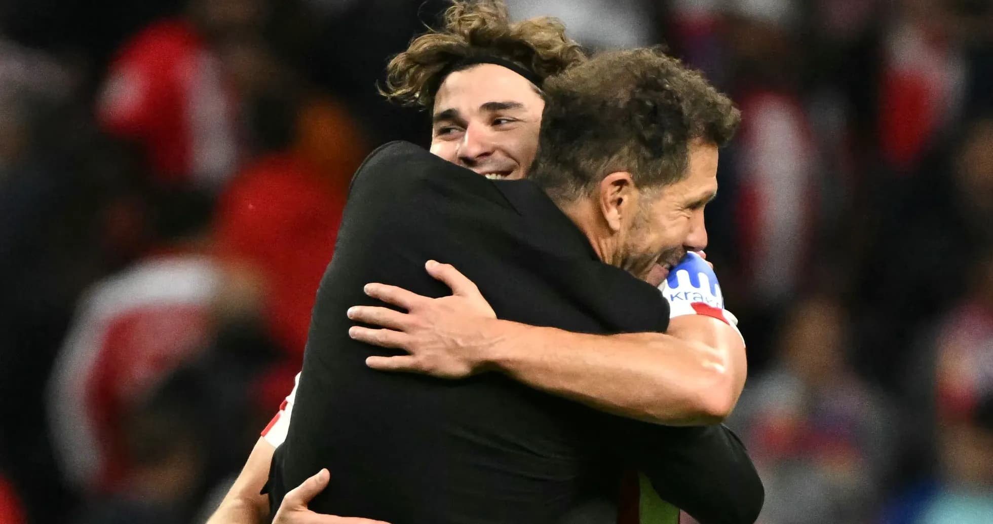 Entrenador y jugador abrazándose tras el partido