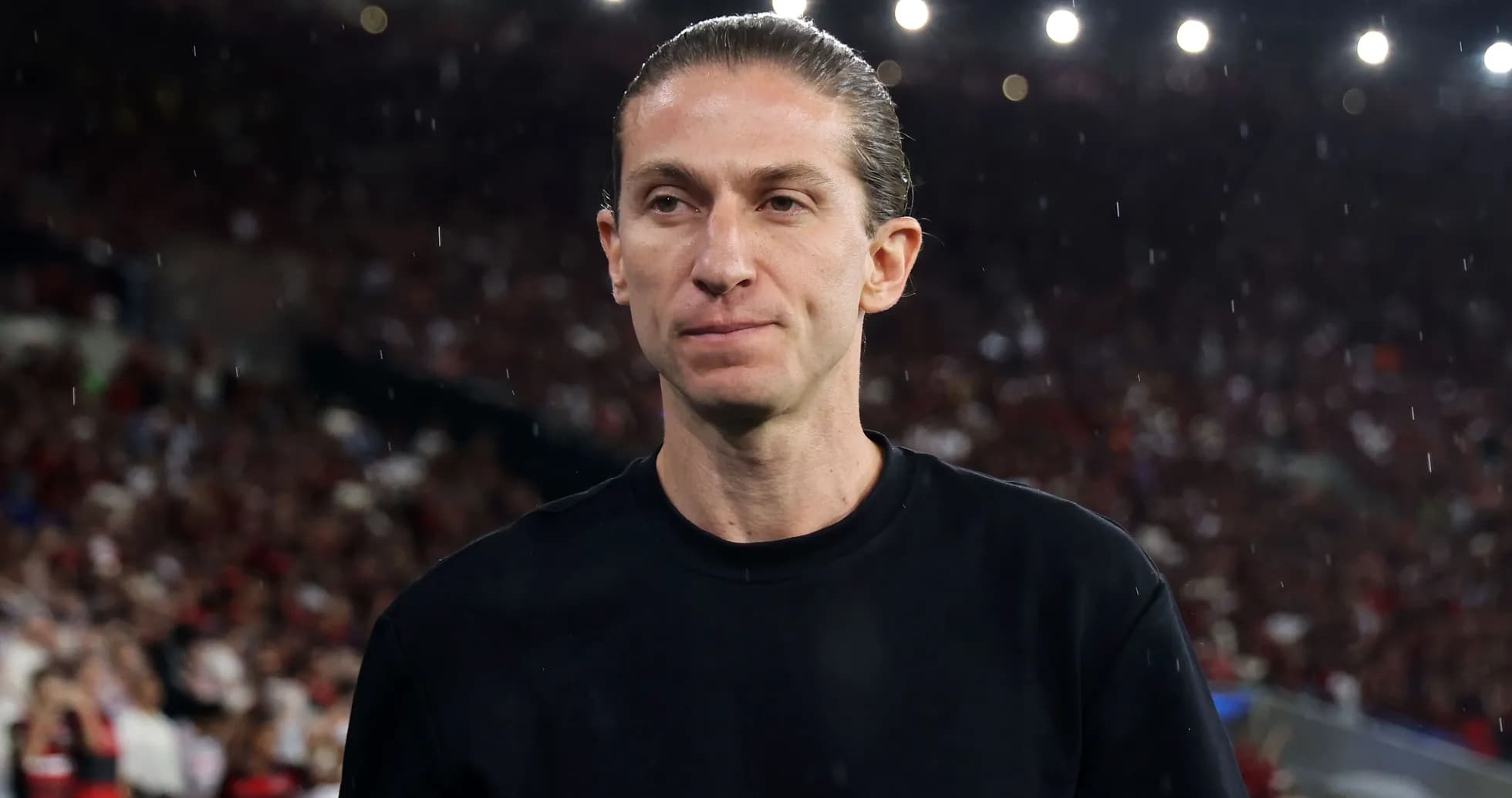 Entrenador en el campo con público de fondo