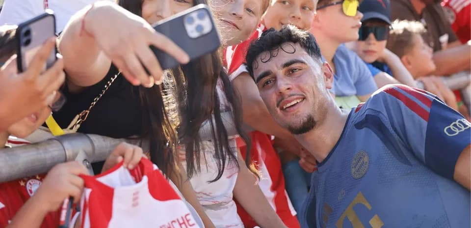 Jugador sonriendo mientras fans se toman selfies