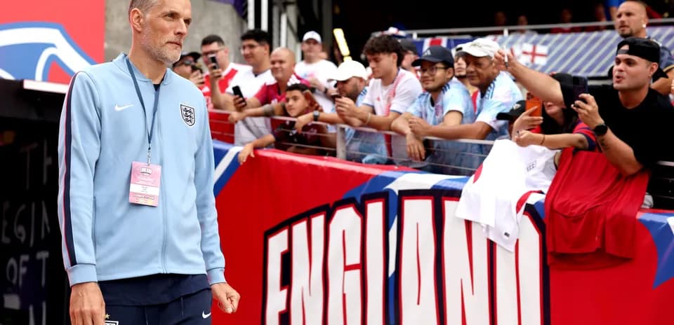 Entrenador camina hacia la cancha con aficionados detrás