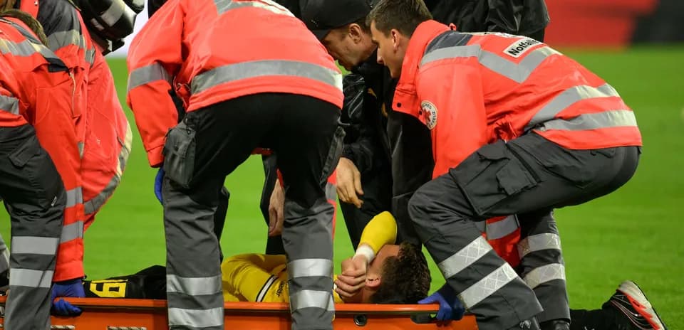Equipo médico atendiendo a un jugador en camilla
