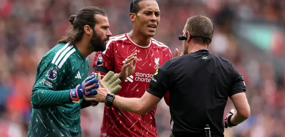 Jugadores de Liverpool discutiendo con el árbitro