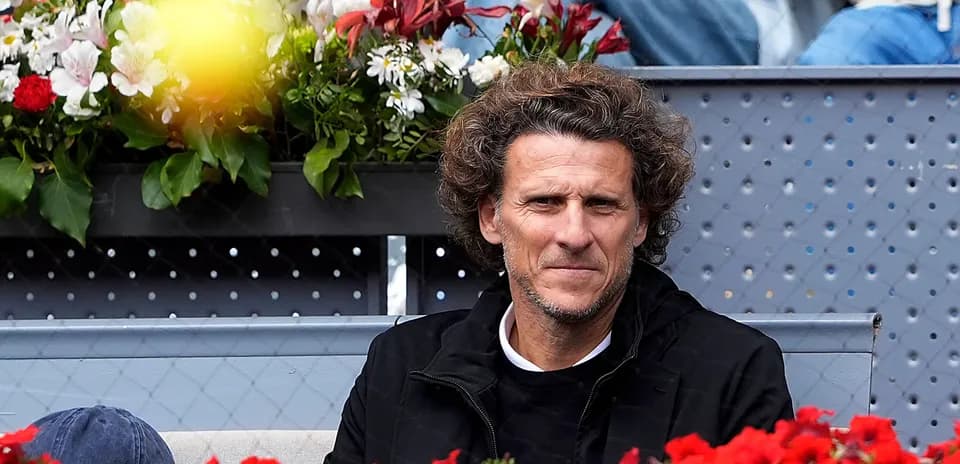 Hombre sentado frente a flores en un evento deportivo