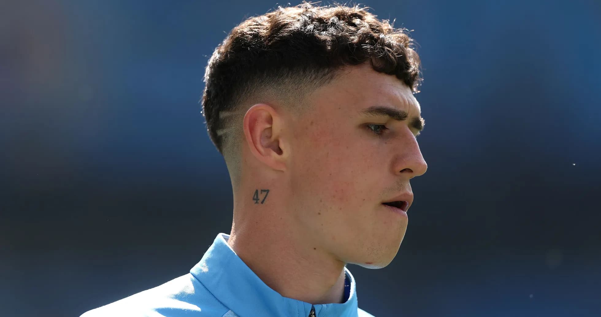 Jugador con tatuaje y camiseta azul en el campo