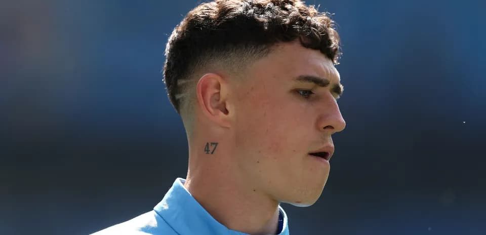 Jugador con tatuaje y camiseta azul en el campo