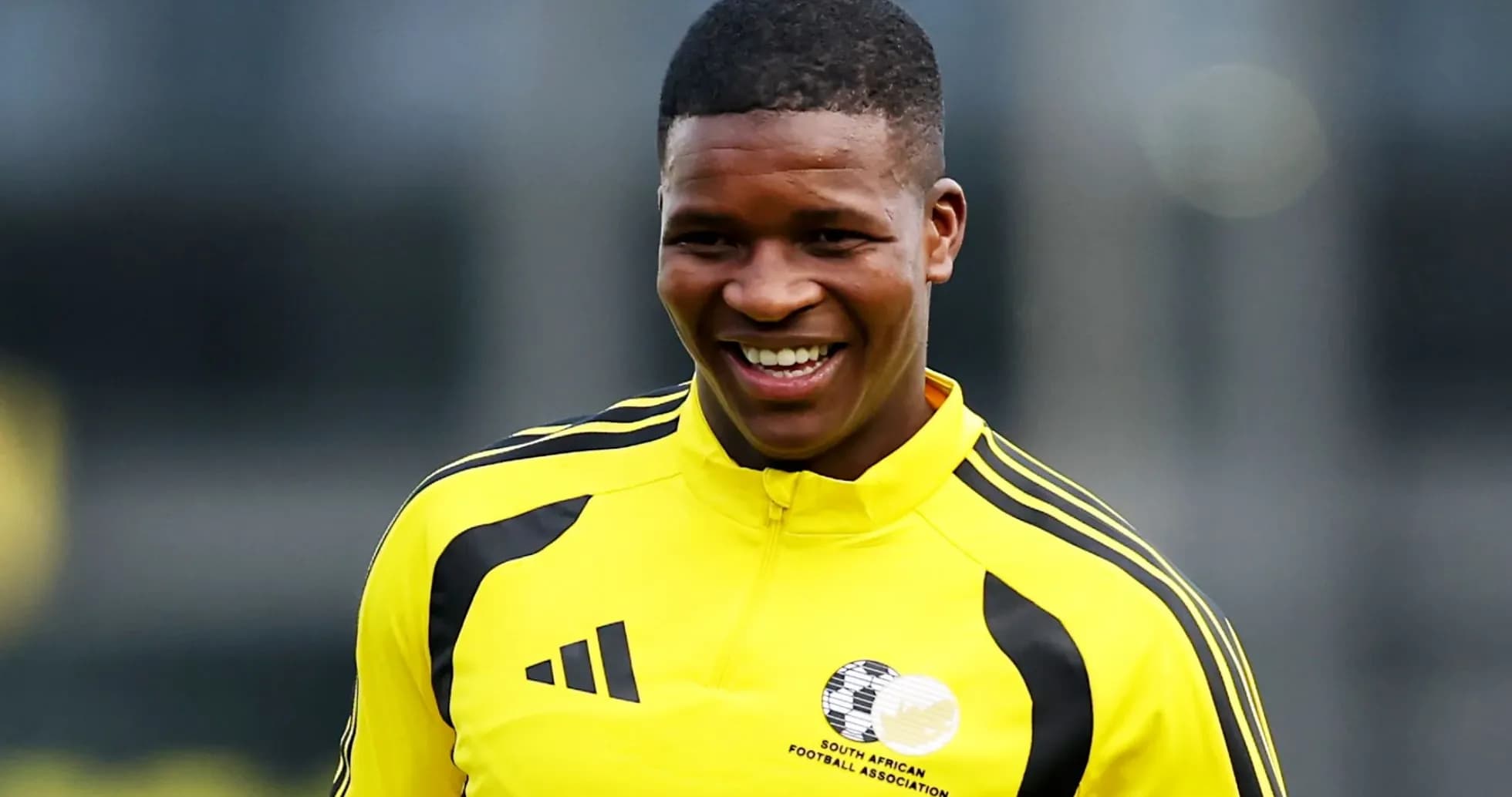 Jugador sonriente en uniforme amarillo de entrenamiento