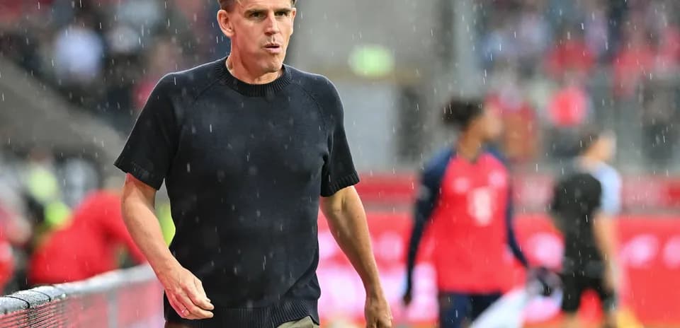 Entrenador caminando en la lluvia durante el partido
