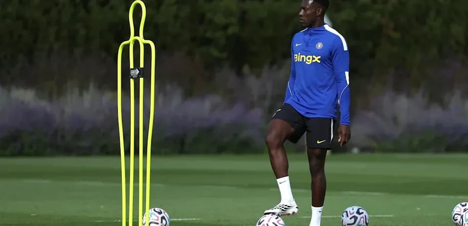 Jugador entrenando junto a conos y balones de fútbol