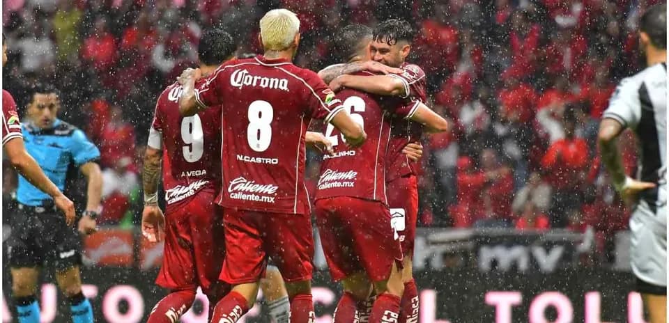 Jugadores de Toluca celebrando un gol en lluvia