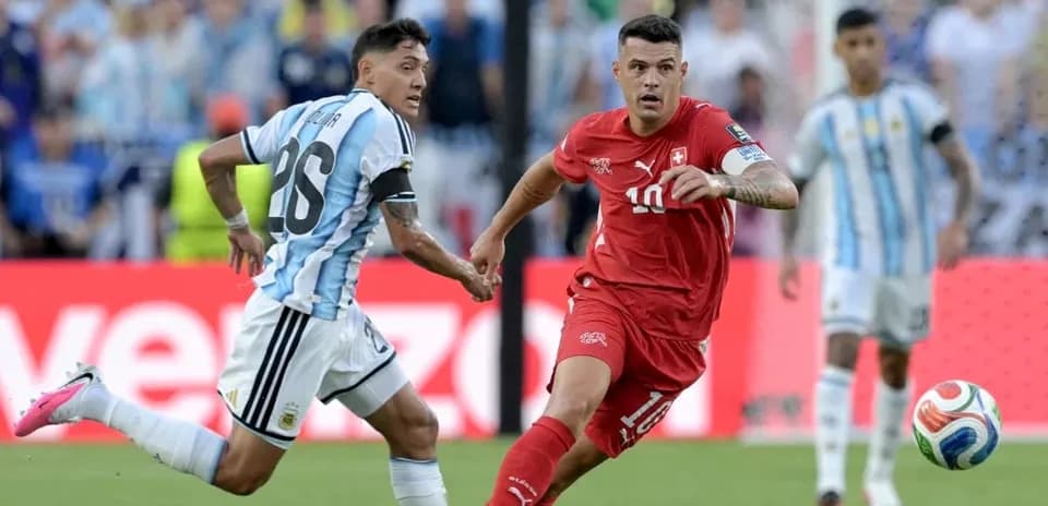 Jugador suizo corriendo con balón mientras es seguido