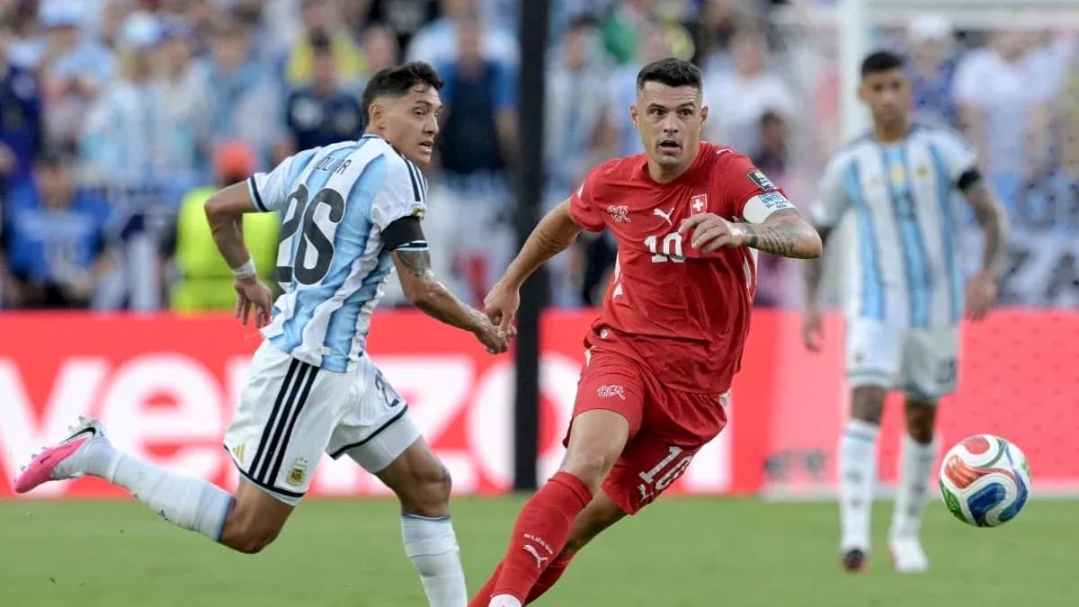 Jugador suizo corriendo con balón mientras es seguido