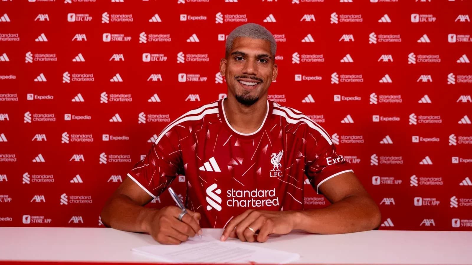Jugador firmando contrato con Liverpool en rueda de prensa