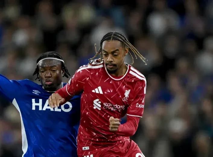 Jugador de Liverpool driblando ante rival de Everton