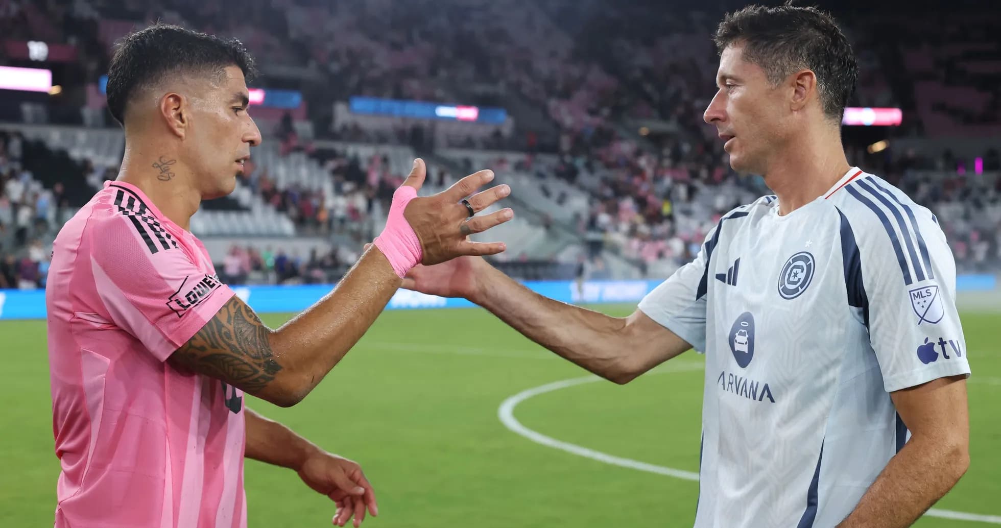 Jugadores saludándose tras el partido en el campo