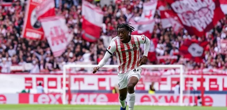 Jugador corriendo con el balón en estadio lleno