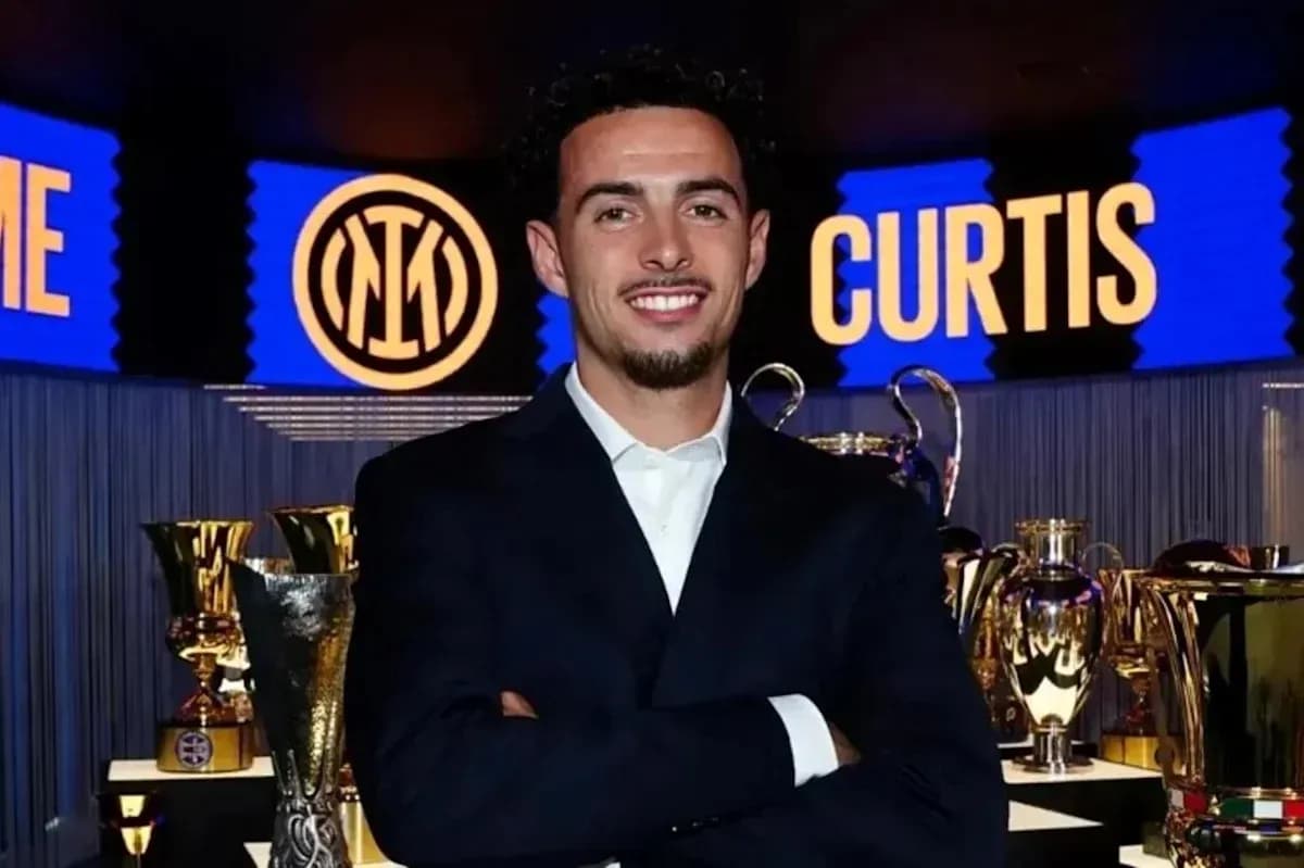 Persona sonriendo frente a trofeos en evento