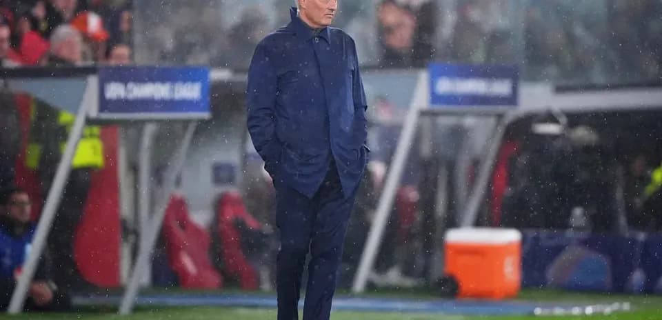 Entrenador observando el partido bajo la lluvia